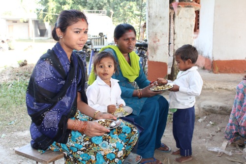 Nisha spiser frokost med sin datter. En af fordelene ved, at mødrene laver mad er, at de på den måde får en chance for at blive mere engagerede i deres børns skoleliv.